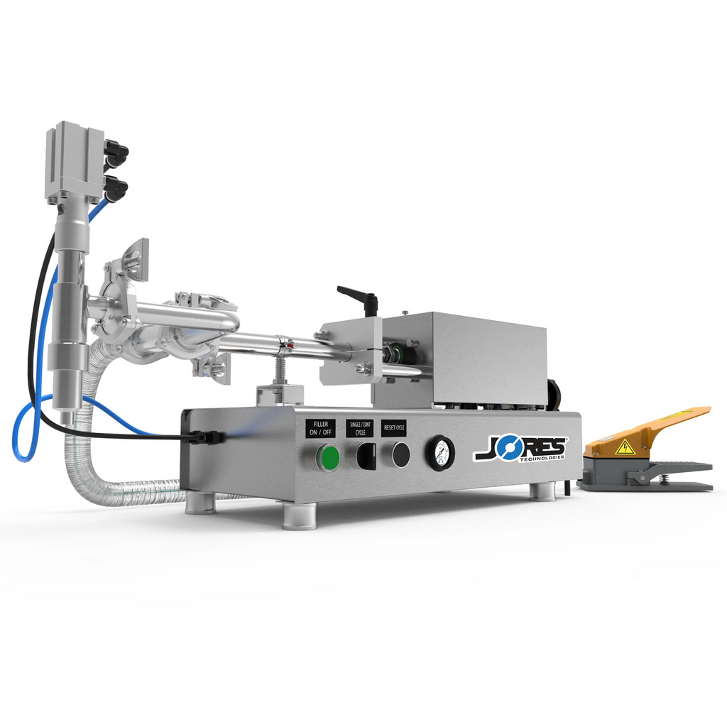 Low viscosity JORES TECHNOLOGIES® piston filling machine with 316 and 304 SS. The piston filler is made out of stainless steel and there's a yellow and grey foot pedal resting on the side which is part of the filler.